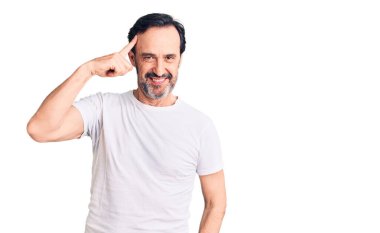 Orta yaşlı, sıradan tişörtler giyen yakışıklı bir adam tek parmağıyla kafasını gösteren, harika bir fikir ya da düşünce, iyi bir hafıza. 