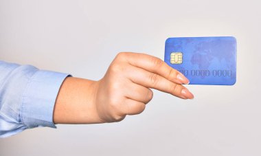 İzole edilmiş beyaz arka planda kredi kartı tutan beyaz bir kadının eli.