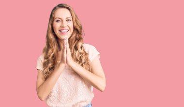 Sarışın, güzel, beyaz bir kadın. Sıradan kıyafetler giyiyor. Elleriyle dua ediyor, af diliyor.. 