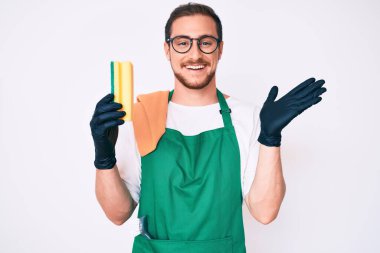 Önlük takan yakışıklı genç adam zaferi mutlu bir gülümsemeyle ve el kaldırarak kazanan ifadeyle kutluyor. 