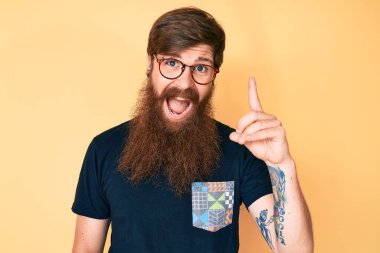 Uzun sakallı, sıradan kıyafetler giyen ve gözlüklü, parlak fikirli, yakışıklı, genç bir adam. Heyecanlı ve mutlu. Bir numara.. 