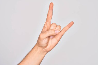 Beyaz arka planda parmaklarını gösteren beyaz tenli bir gencin eli. Rock 'n Roll sembolü, müstehcen boynuzlar gösteriyor.
