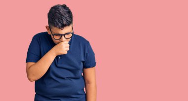 Günlük kıyafetler ve gözlük takan küçük çocuk kendini kötü hissediyor ve soğuk algınlığı veya bronşitin belirtisi olarak öksürüyor. sağlık hizmeti kavramı. 