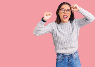 Genç, güzel Çinli bir kız, kızgın ve kızgın. Öfkeyle bağırırken yumruklarını kaldırıyor. öfke ve agresif konsept. 