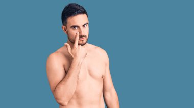 Mayo giyen genç ve yakışıklı bir adam senin hareketlerini seyrediyor. Şüpheli bir ifade. 