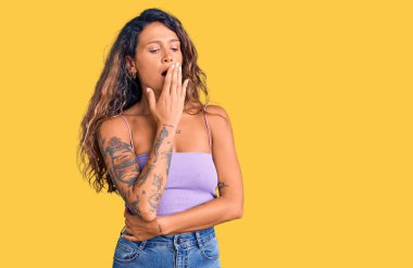 Günlük kıyafetler giyen İspanyol bir kadın. Ağzı eliyle kapatmaktan sıkılmış. Huzursuz ve uykulu.. 