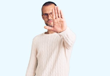 Gündelik kıyafetler giyen ve gözlük takan genç yakışıklı adam avucunun içi gibi şarkı söylemeyi kesiyor. Yüzünde olumsuz ve ciddi bir jest olan uyarı ifadesi. 