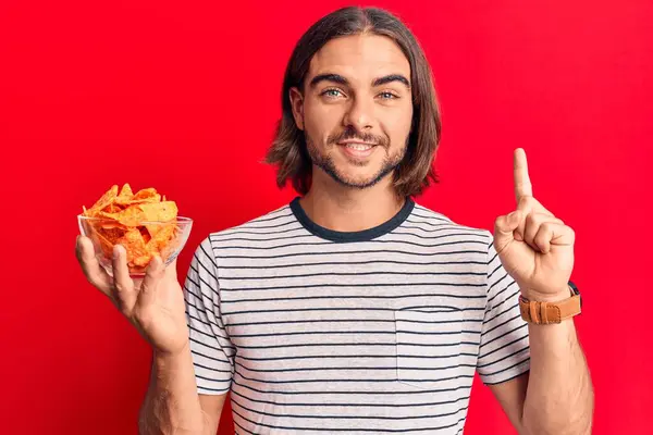 Fiatal Jóképű Férfi Nachos Chipsszel Kezében Mosolygott Egy Ötlettel Vagy — Stock Fotó