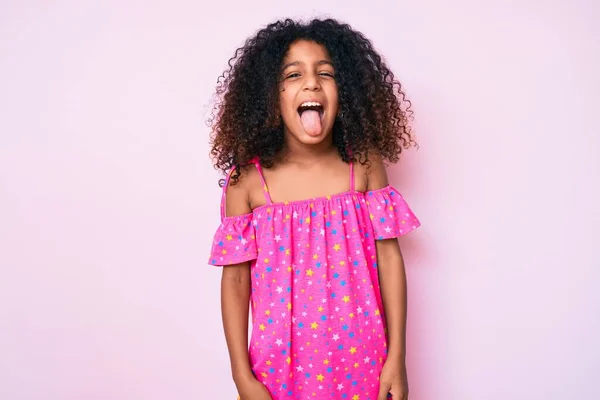 面白い表情で幸せ舌を突き出すカジュアルなドレスを着て巻き毛を持つアフリカ系アメリカ人の子供 感情の概念 — ストック写真