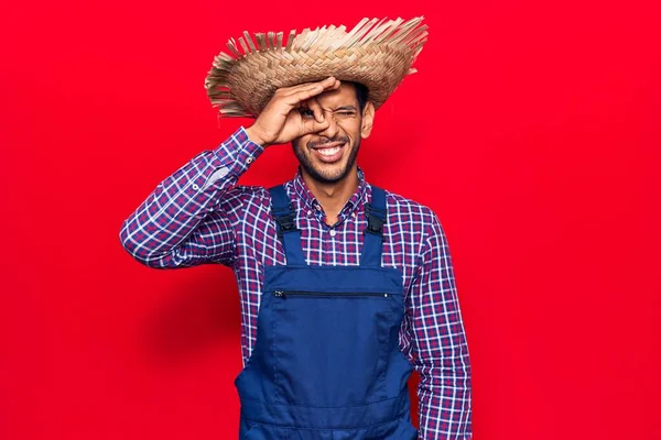 Çiftçi Şapkası Önlüğü Takan Genç Latin Adam Hareketleriyle Gülümsüyor Mutlu — Stok fotoğraf