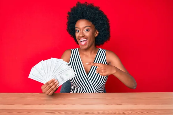 Joven Mujer Afroamericana Sosteniendo Dólares Sonriendo Feliz Señalando Con Mano —  Fotos de Stock