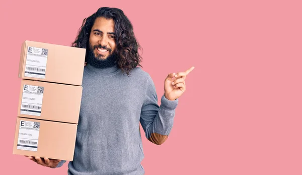 Ung Arabisk Man Håller Leverans Paket Ler Glad Pekar Med — Stockfoto