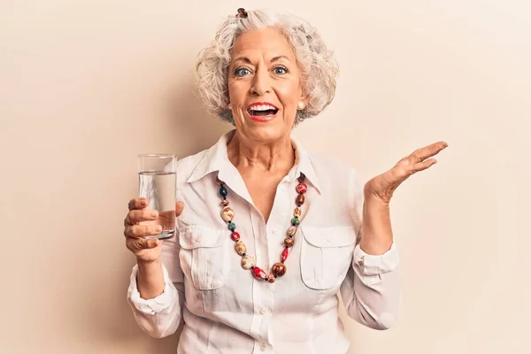 幸せな笑顔で水を飲む先輩白髪の女性と育った手で勝者の表情 — ストック写真