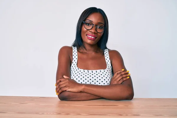 Genç Afro Amerikan Kadın Günlük Giysiler Gözlük Takmış Masaya Oturmuş — Stok fotoğraf