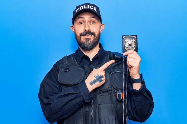 Mladý Pohledný Muž Policejní Uniformě Drží Zbraň Úsměvem Šťastný Ukazuje — Stock fotografie