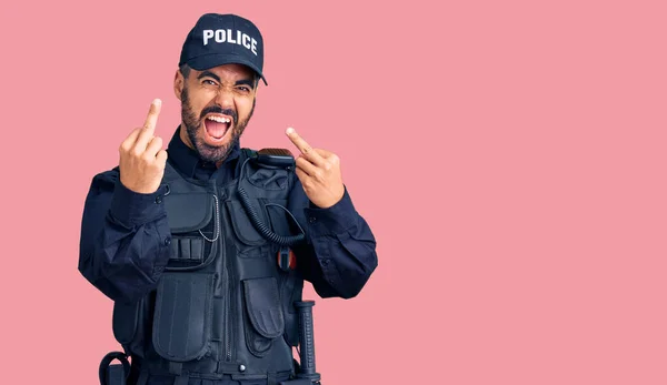 Young Hispanic Man Wearing Police Uniform Showing Middle Finger Doing — стоковое фото