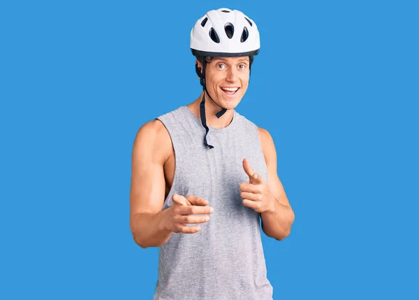 年轻英俊的男子戴着自行车头盔 手指指向镜头 脸上洋溢着欢乐和滑稽的表情 充沛的精力和活力 — 图库照片