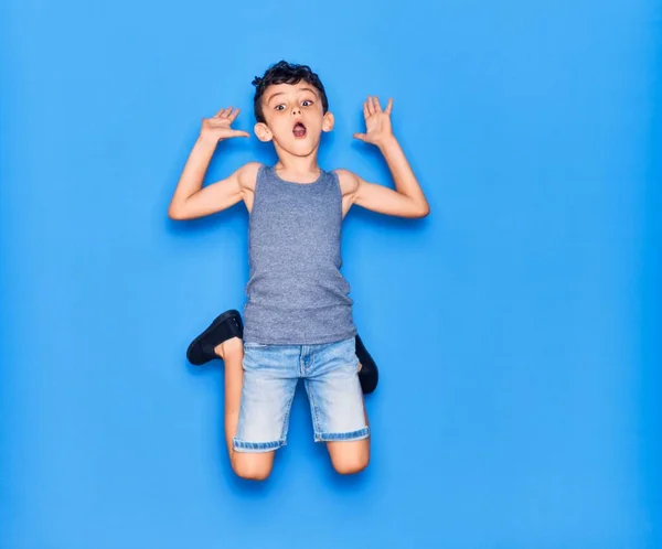 Adorable Niño Con Ropa Casual Saltando Sobre Fondo Azul Aislado — Foto de Stock