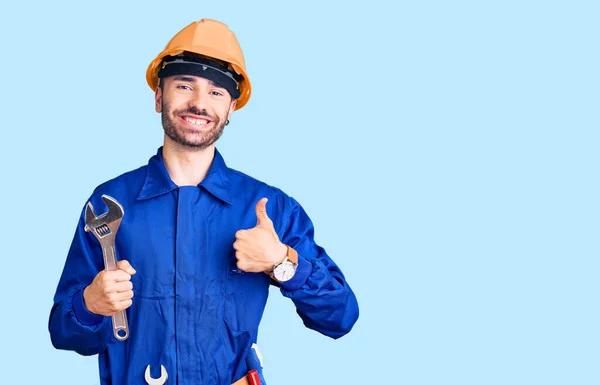 Ung Latinamerikan Man Bär Elektriker Uniform Håller Skiftnyckel Ler Glad — Stockfoto