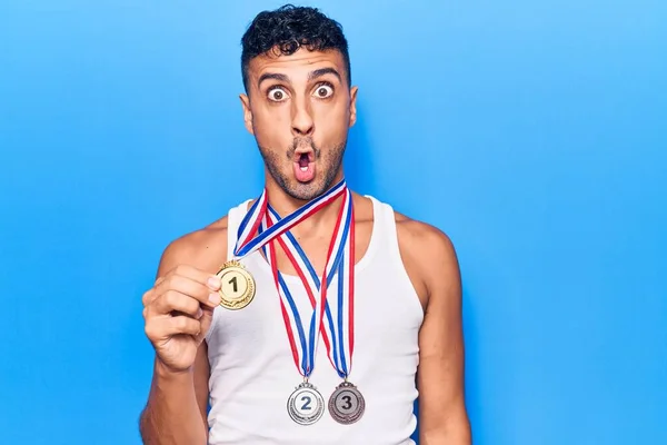 Młody Hiszpan Noszący Medale Zwycięzcy Przestraszony Zdumiony Otwartymi Ustami Dla — Zdjęcie stockowe