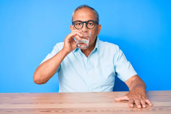 Pohledný Starší Muž Sedí Doma Stole Pije Sklenici Čerstvé Vody — Stock fotografie