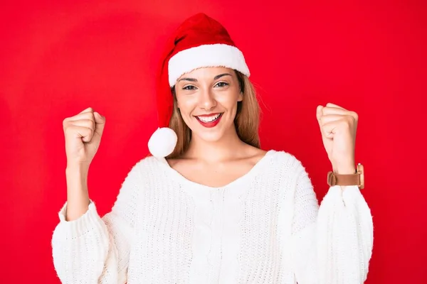 年轻的黑发女子戴着圣诞礼帽 自豪地尖叫着 高举双臂庆祝胜利和成功 — 图库照片