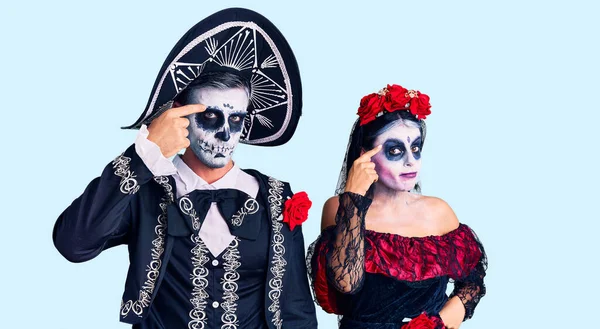 若いカップルの背景に死んだ衣装のメキシコの日を着て額ににきび 黒頭の醜い感染に不幸な指している にきびや皮膚の問題 — ストック写真
