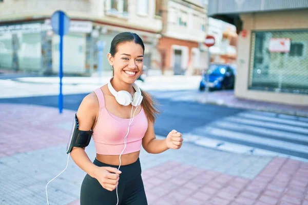 Młoda Piękna Hiszpanka Stroju Biegacza Słuchawkach Uśmiechnięta Szczęśliwa Biegając Mieście — Zdjęcie stockowe