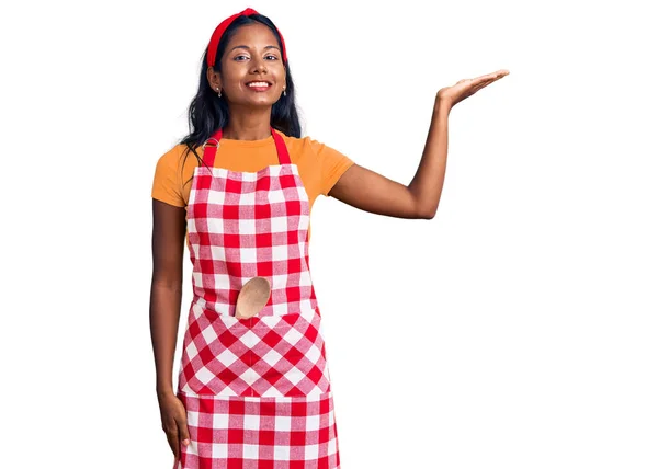 Молодая Индийская Девушка Профессиональном Фартуке Пекаря Улыбается Веселым Подарком Указывает — стоковое фото
