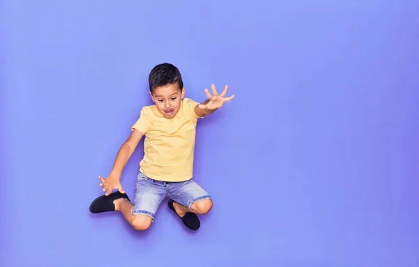 Criança Adorável Vestindo Roupas Casuais Pulando Sobre Fundo Roxo Isolado — Fotografia de Stock