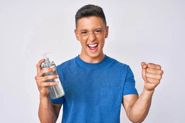 Young Hispanic Boy Using Hand Sanitizer Gel Screaming Proud Celebrating — Stock Photo, Image