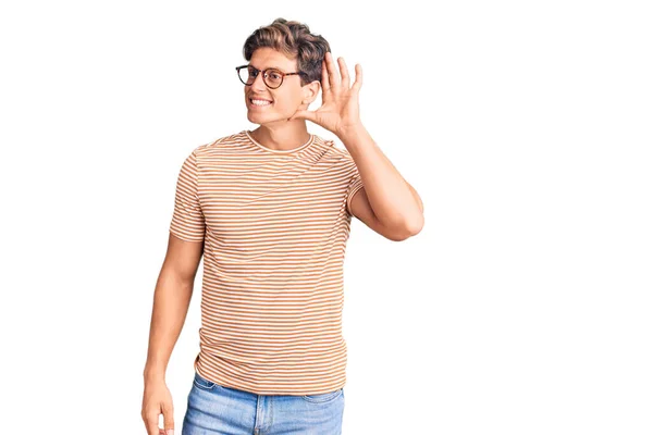 年轻英俊的男人穿着休闲装 戴着眼镜 两手空空地听着流言蜚语 聋的概念 — 图库照片