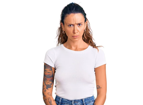 Ung Latinamerikansk Kvinna Med Tatuering Klädd Avslappnad Vit Tröja Skeptisk — Stockfoto