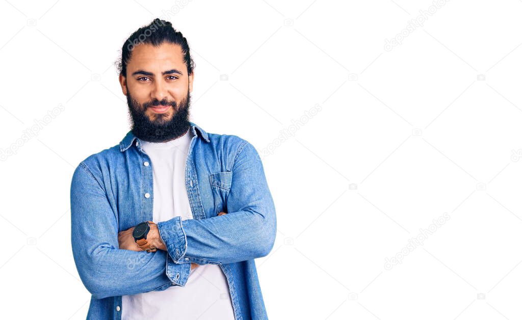 Young arab man wearing casual denim shirt happy face smiling with crossed arms looking at the camera. positive person. 