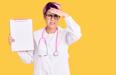 Pembe saçlı, doktor steteskobu takan genç ve güzel bir kadın. Elinde bir pano, elinde tıbbi raporla gergin ve sinirli bir yüz ifadesi var. 