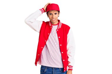 Beyzbol üniforması giyen Afrikalı genç bir Amerikalı soru sorup kafasını karıştırıyor. Şüpheyle kararsız, kafa kafaya düşünerek. Düşünceli kavram. 