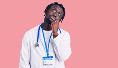 Saç örgülü, doktor steteskobu takan ve ciddi bir yüz ifadesi takan genç Afro-Amerikan bir adam. Elleri çenesinde soru sorarken, kafa karıştırıcı bir fikir hakkında düşünceli. 