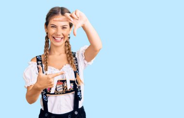 Sarışın, güzel, beyaz bir kadın. Geleneksel kıyafetler giyiyor. Gülümsüyor, elleri ve parmakları gülen yüzlü bir çerçeve yapıyor. yaratıcılık ve fotoğrafçılık kavramı. 