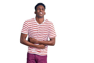 Genç Afro-Amerikalı bir adam elleri karnında günlük kıyafetler giyiyor çünkü mide bulantısı, acı verici bir hastalık kendini iyi hissetmiyor. Ağrı kavramı. 