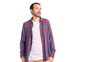 Gündelik kıyafetler giyen genç yakışıklı adam gülümseyerek yan tarafa bakıyor ve düşünüyor.. 