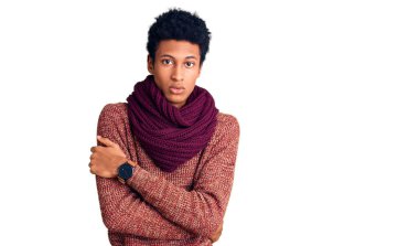 Genç Afro-Amerikan adam, günlük kışlık süveter ve eşarp giyerek kış soğuğu için titriyor ve donuyor. Yüzünde üzgün ve şok ifadesi var. 