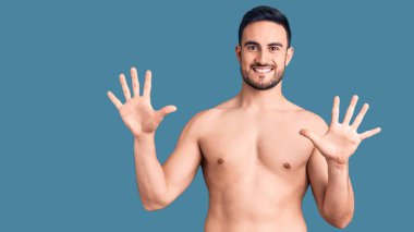 Mayo giyen genç yakışıklı adam 10 numarayı gösterip işaret ederken kendinden emin ve mutlu bir şekilde gülümsüyor.. 