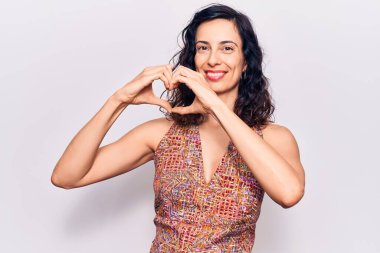 Gündelik kıyafetler giyen, aşık gülümseyen, elleriyle kalp sembolü yapan genç, güzel İspanyol bir kadın. romantik kavram. 