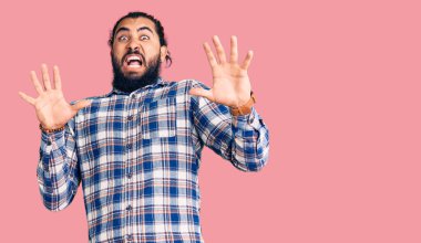 Gündelik giysiler giyen genç Arap adam korku ifadesinden korkmuş ve dehşete düşmüş. El hareketlerini durdur, şok içinde bağır. panik konsepti. 