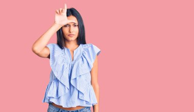 Genç ve güzel Latin kız gündelik kıyafetler giyiyor. Alnında parmakları olan insanlarla dalga geçiyor. Ezik hareketler yapıyor, alay ediyor ve hakaret ediyor.. 