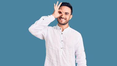 Genç, yakışıklı, günlük kıyafetler giyen, gülümseyen, mutlu, el pençe divan duran, el pençe divan duran. 