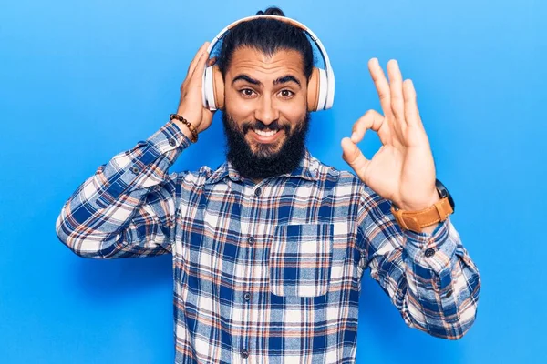 Young Arab Man Listening Music Using Headphones Doing Sign Fingers — Stock Photo, Image