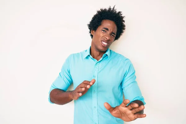 アフロの髪をしたハンサムなアフリカ系アメリカ人の男性は カジュアルな服を着て嫌悪反応のために嫌悪感の表情 不満と恐怖を行う嫌悪感の顔 手を挙げて — ストック写真