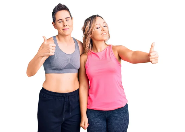 Couple Women Wearing Sportswear Looking Proud Smiling Doing Thumbs Gesture — Stock Photo, Image
