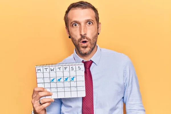 Young Handsome Man Holding Travel Calendar Scared Amazed Open Mouth — Stock Photo, Image